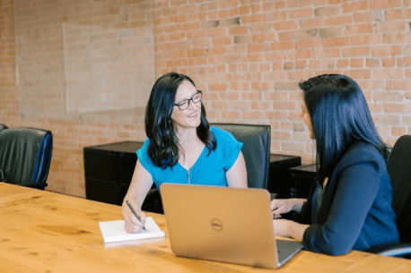Facilitator conducting usability testing with participant looking at laptop screen